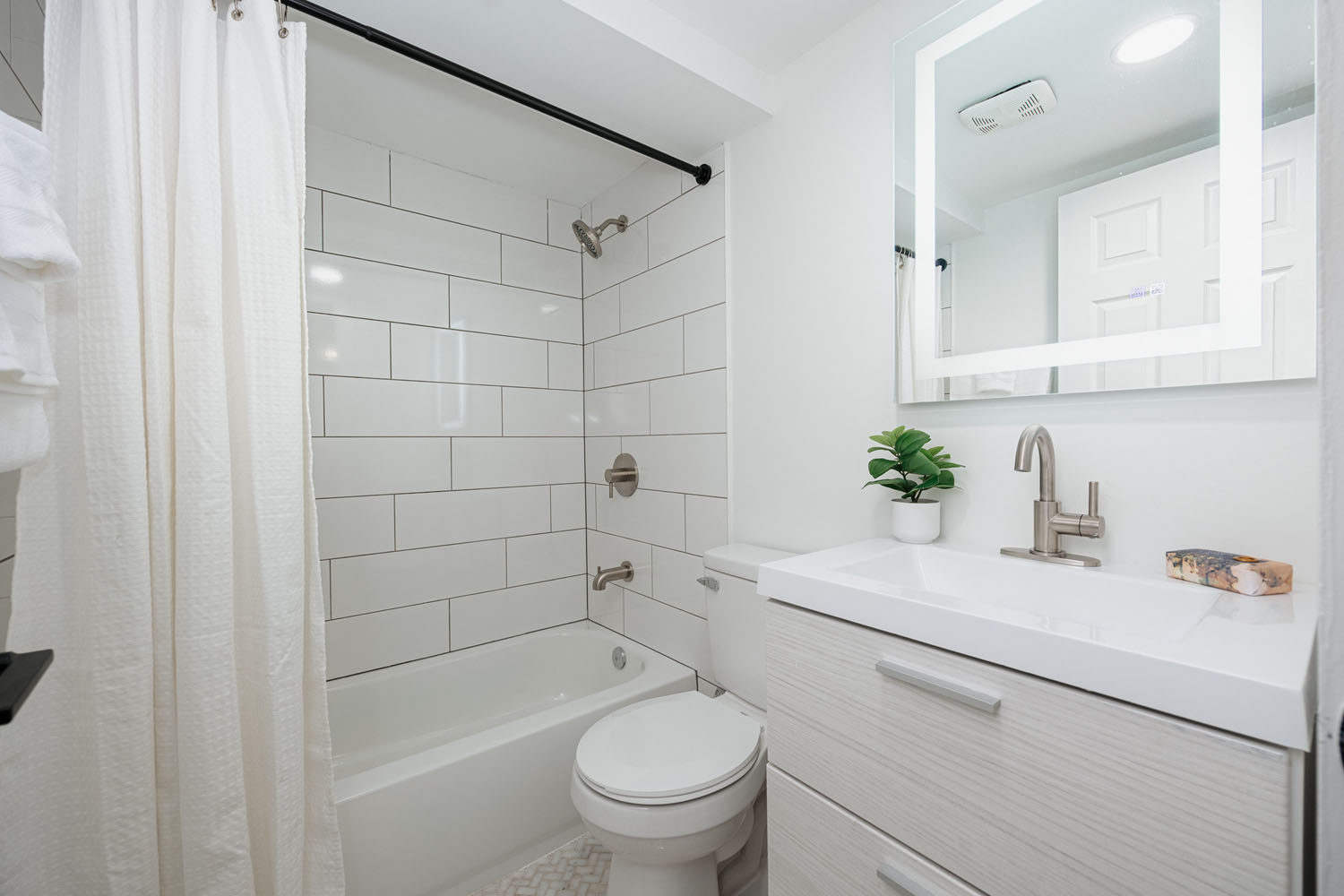 A hallway with a toilet and a sink.