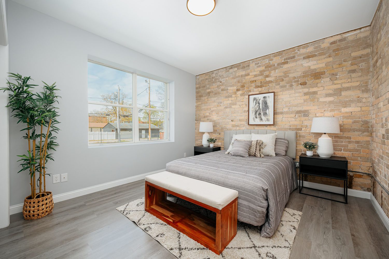 Bedroom with brick wall and bed.