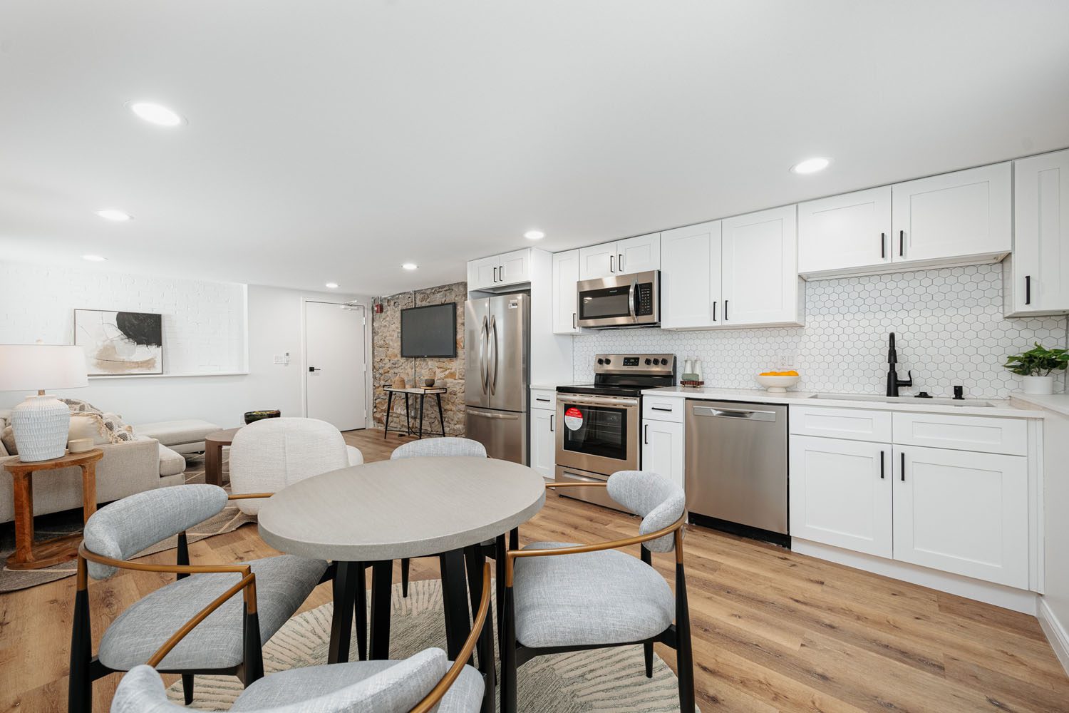 A cozy living room with an open kitchen, comfortable couch, and a convenient washer and dryer setup.